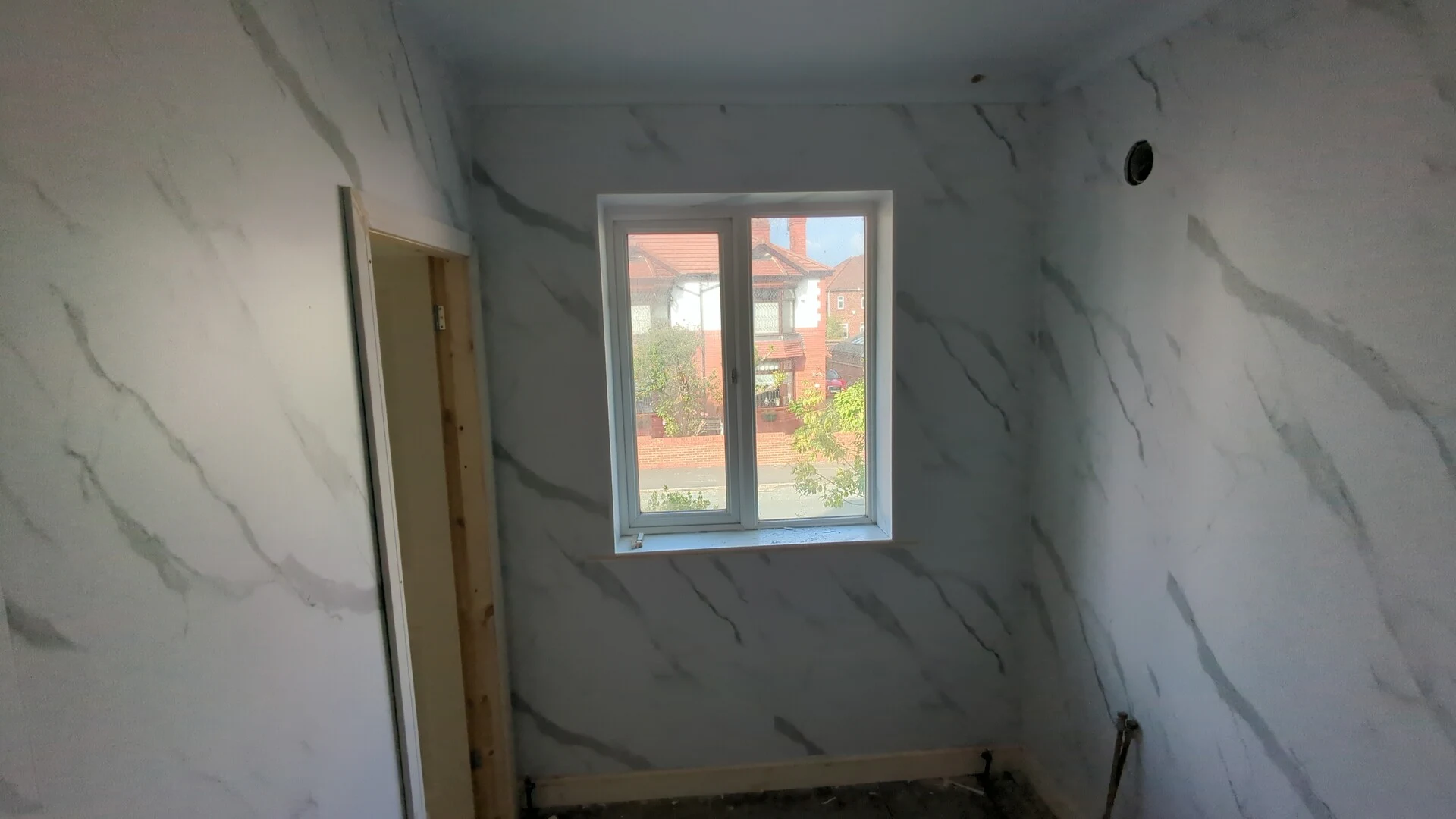 Bathroom cladding fitted around a window reveal in a Doncaster ensuite with plastic finishing trim