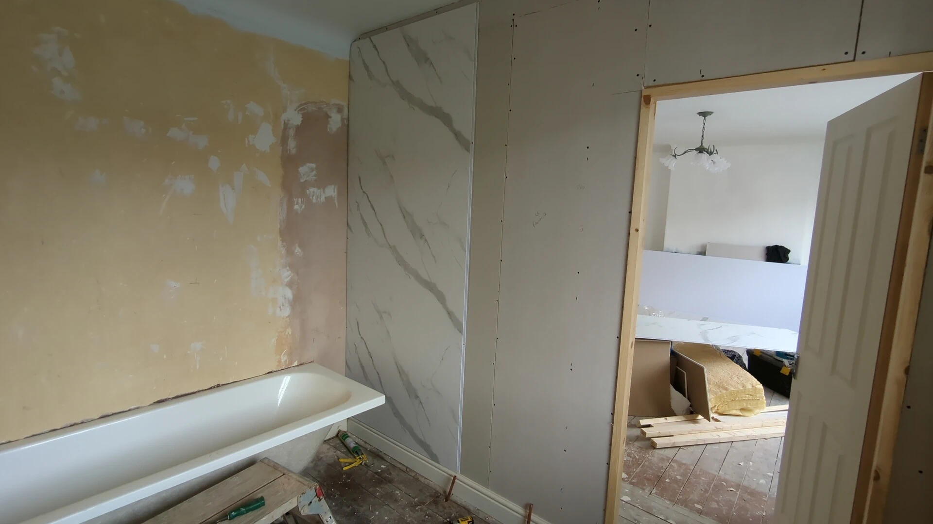 Bathroom wall panel installation in progress in a Doncaster ensuite, first panel fitted beside the bath