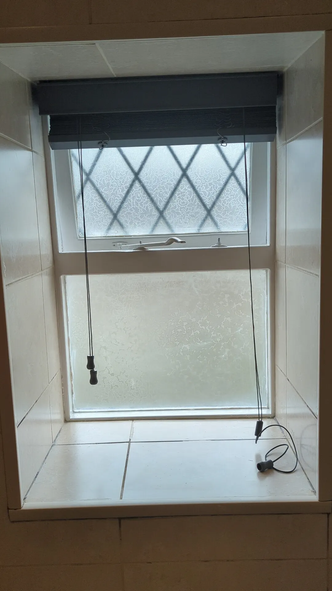 Timber casement window with leaded glazing in a deep stone reveal in a listed cottage in Greengates