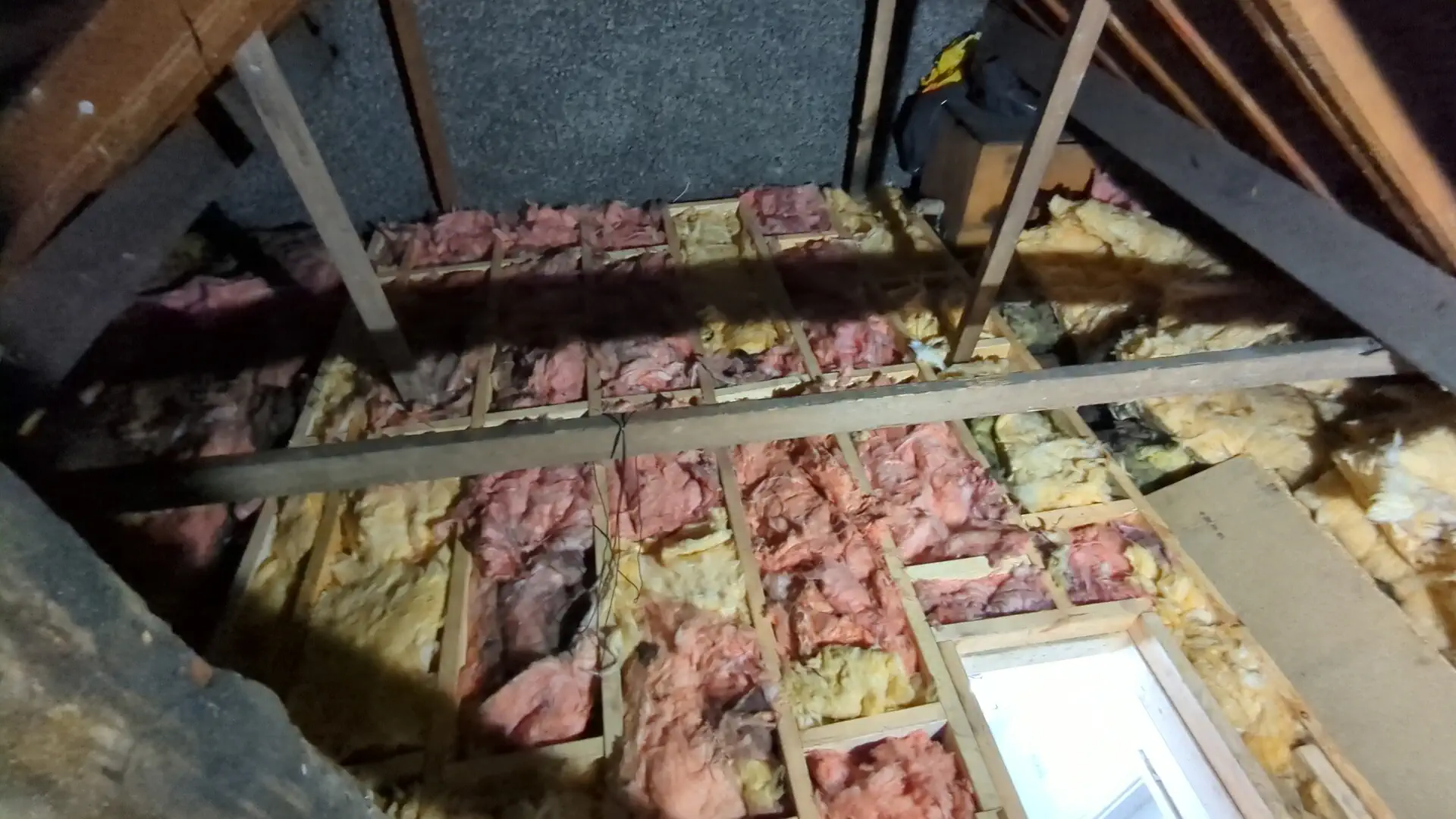 Loft insulation laid between new floor joists before the chipboard flooring goes down