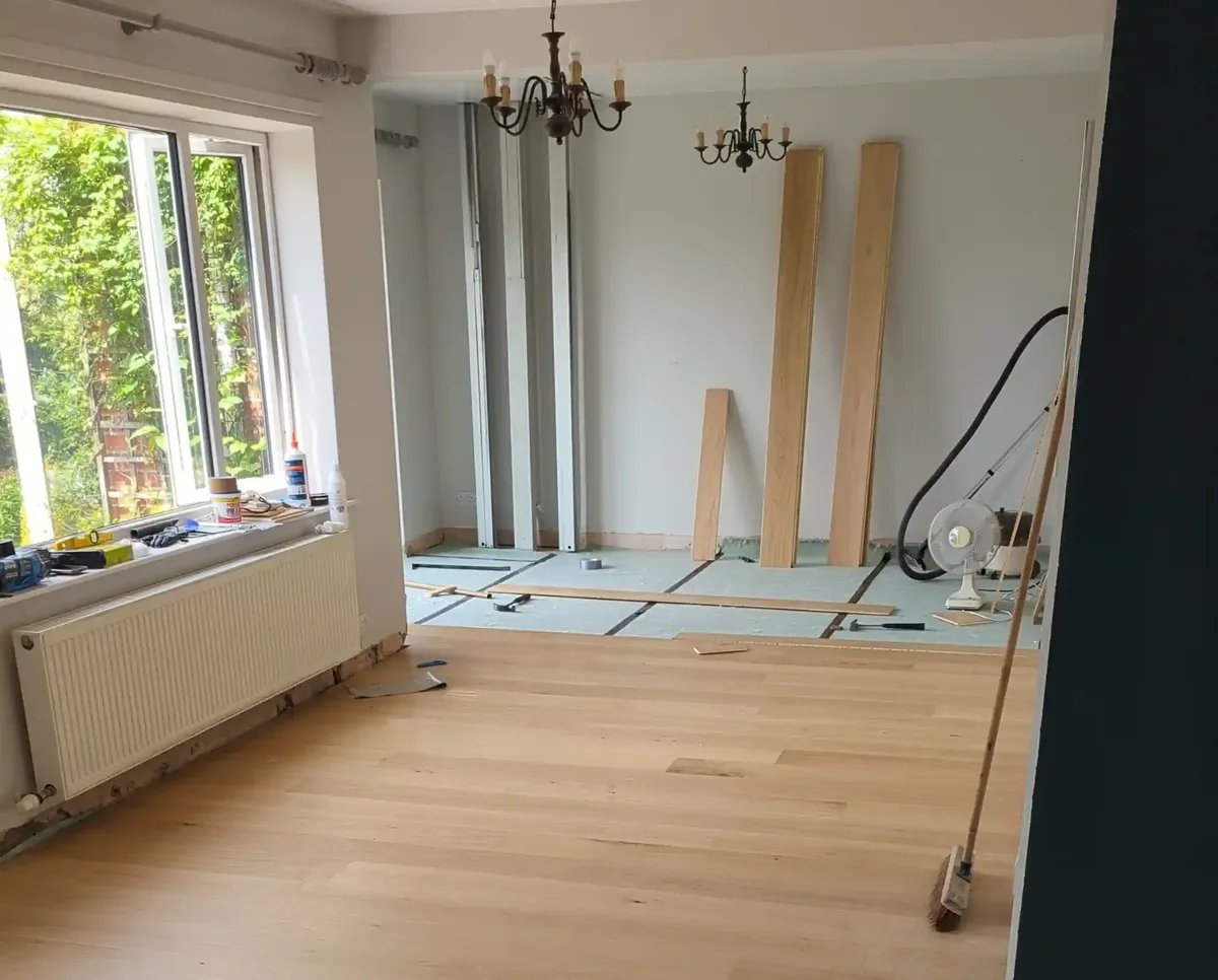 Engineered oak wood flooring being fitted over underlay in a living room