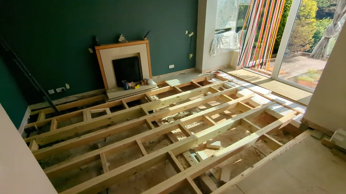 New timber floor joists installed across a living room during floor repair